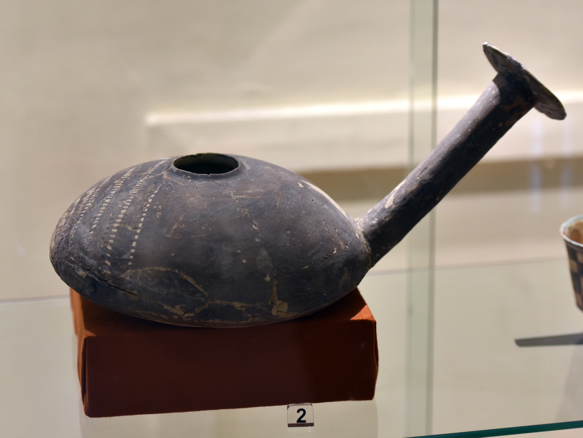 Ancient pottery vessel from Eridu displayed in a museum case.